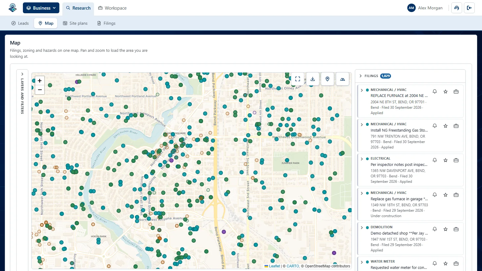 The map over central Bend with about a thousand filings pinned as coloured dots, and the filings in view listed down the right with their trade, address, filing date and build stage.